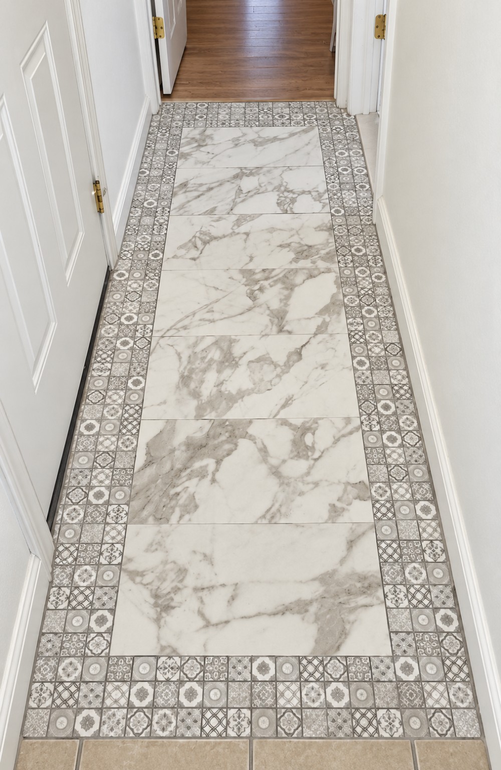 Decorative marble-look hallway tile installation with patterned mosaic border
