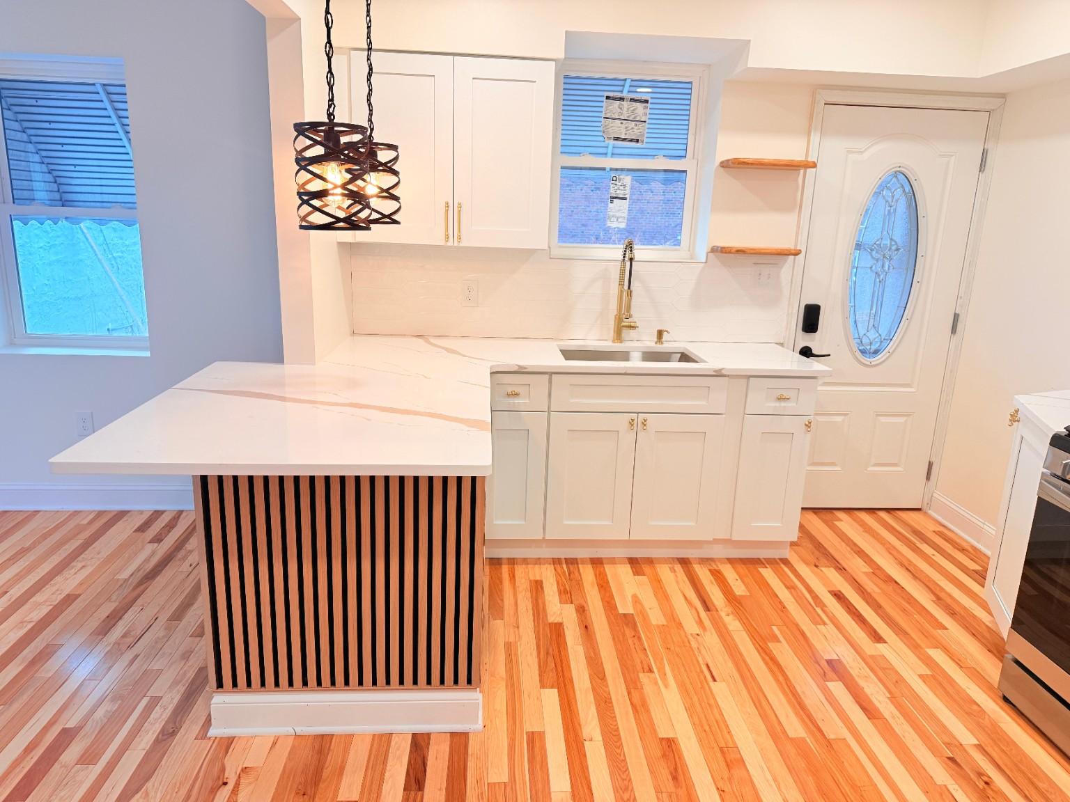 White kitchen remodel with custom wood-slat breakfast bar
